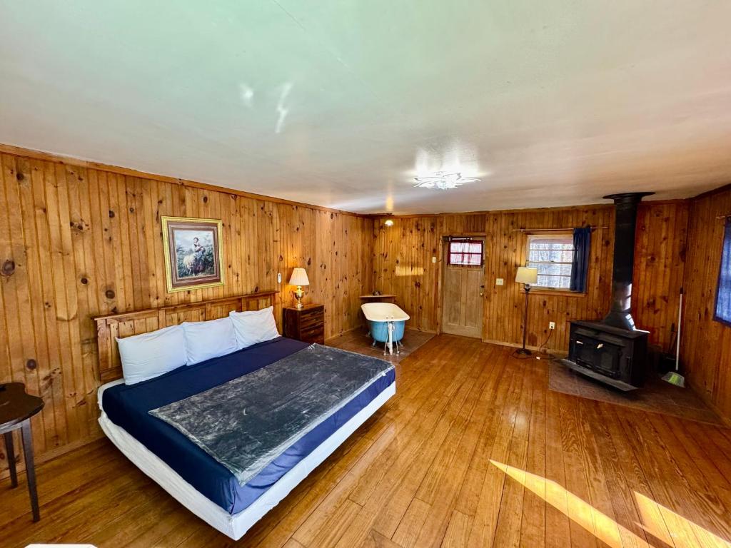a bedroom with a bed and a stove in it at Parkview Lodge & Cabins in Newland