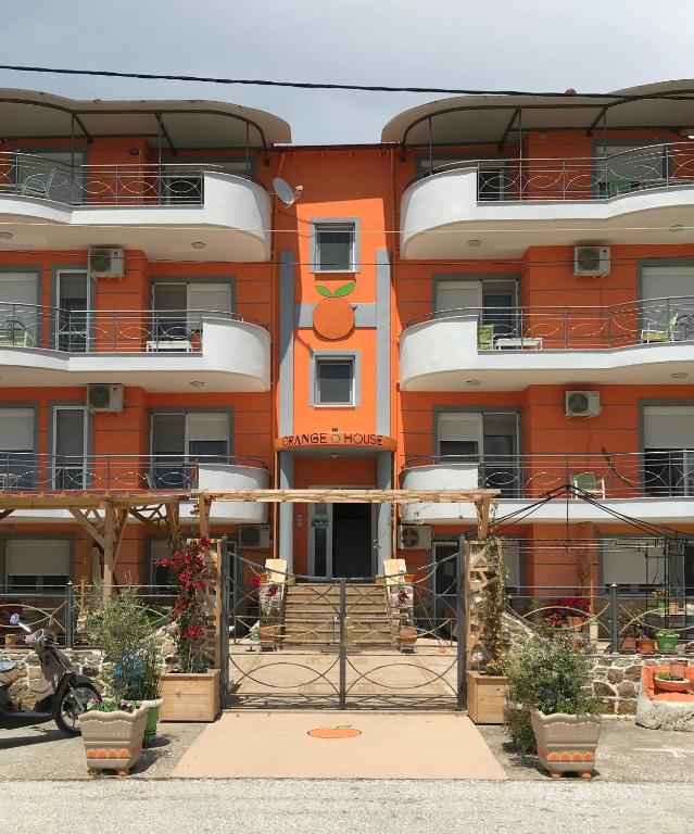 ein orangefarbenes Gebäude mit Balkonen an der Seite in der Unterkunft Orange House in Keramotí