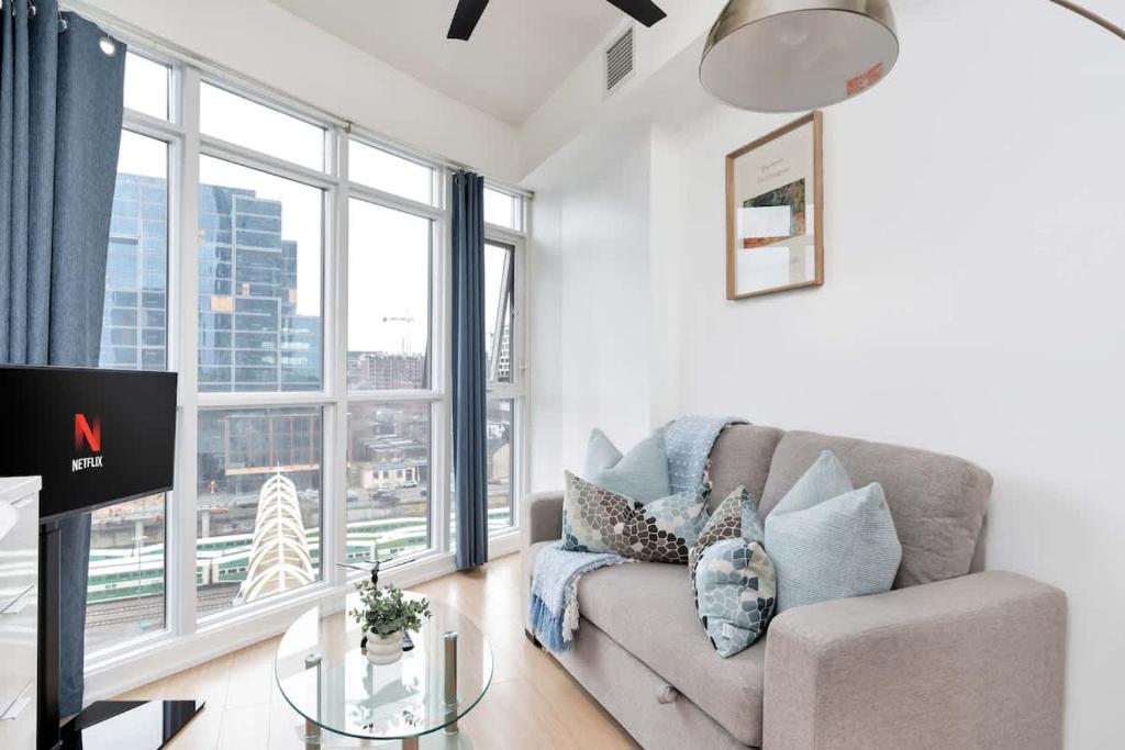 a living room with a couch and a large window at Sunny Downtown TO Studio - Sleeps 3 with 55 TV in Toronto
