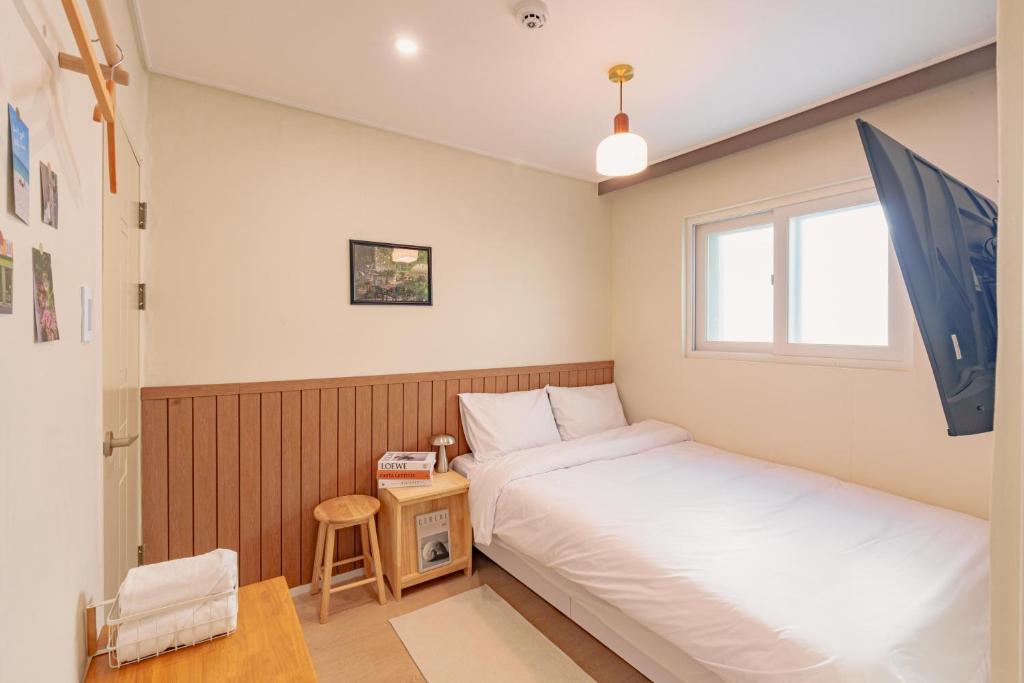 a small bedroom with two beds and a window at Wayhome Gasan in Seoul