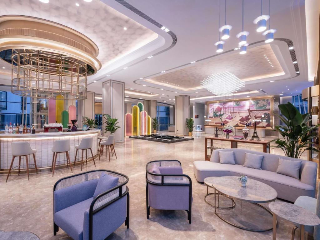 a lobby with a couch and chairs and a bar at Mercure Beijing Downtown in Beijing