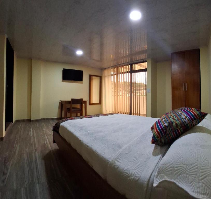 Un dormitorio con una cama grande y una ventana. en Hotel San Marcos Las Lajas, en Ipiales