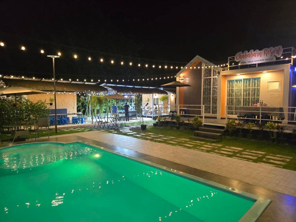 a swimming pool in front of a building at night at Chaba3 in Ban Nong Bua Noi