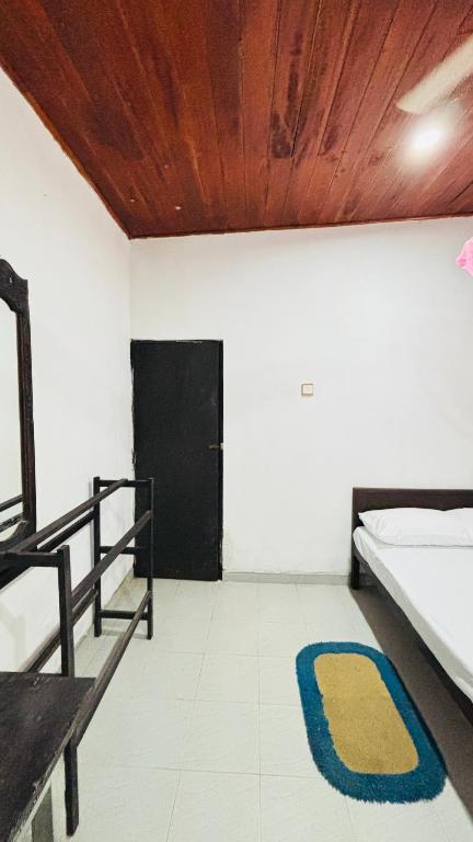a room with a bed and a rug on the floor at Chula,s in Matara