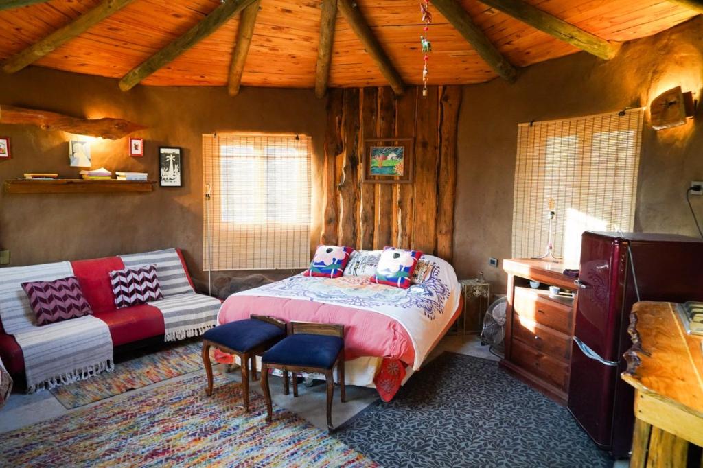 a bedroom with a bed and a couch in a room at Refugio de tierra con vistas en Ocoa in Viña Guzmán