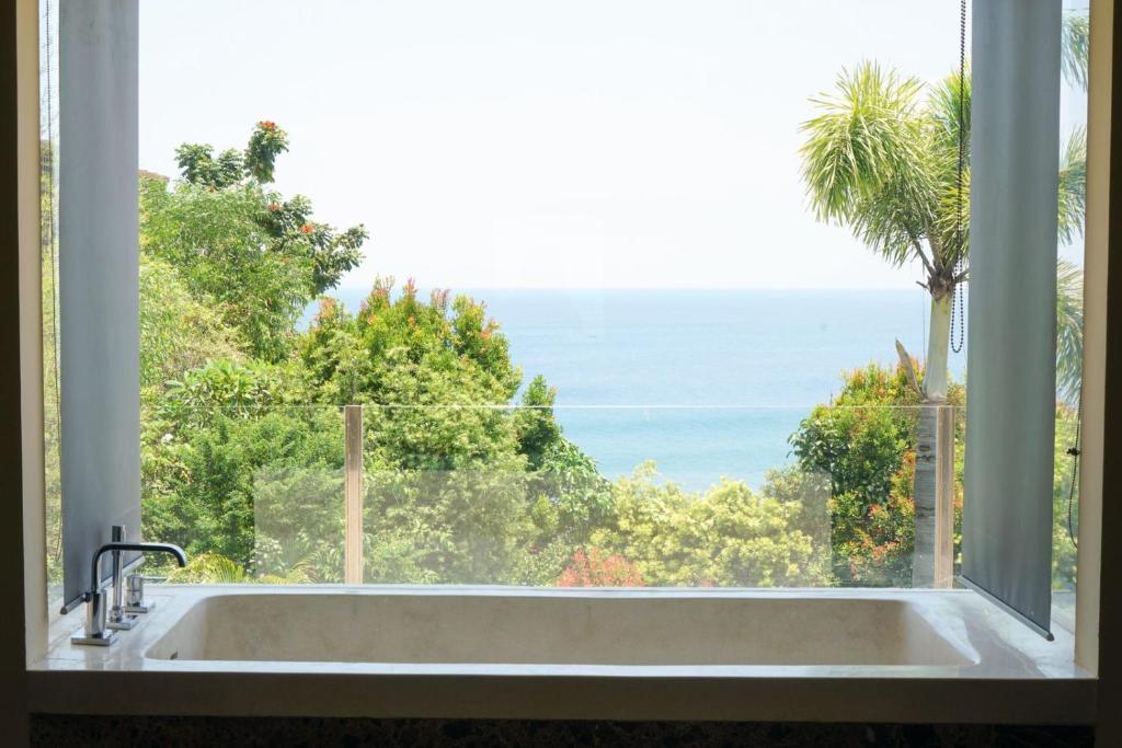 ウルワツにあるVilla Anugrahのバスタブと海の景色が見える窓