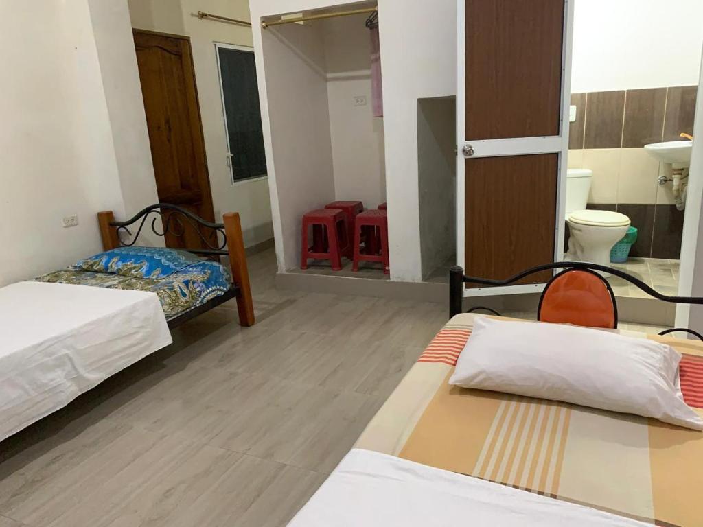 FELIZ ESTADIA Via PRINCIPAL PUERTO LOPEZ في بويرتو لوبيز: غرفة بسريرين وحمام