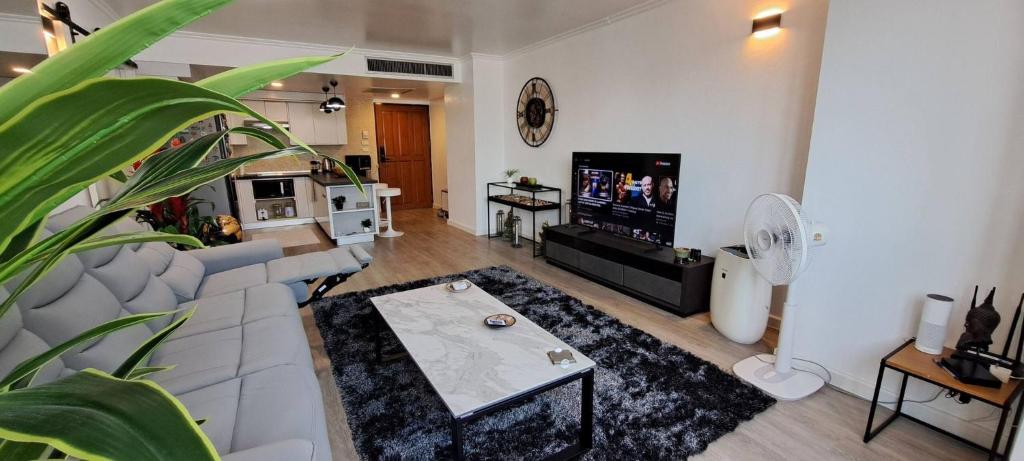 a living room with a couch and a tv at Stylish New Condo in NANA in Bang Kapi