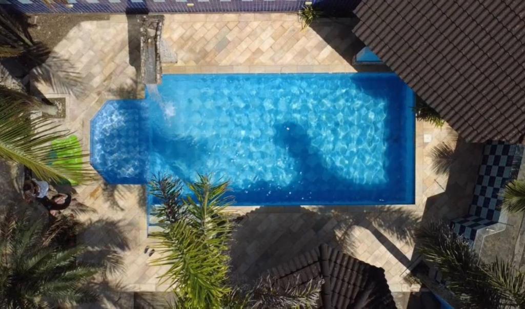 an overhead view of a swimming pool with palm trees at Pousada Preziosa Beach Itanhaém in Itanhaém