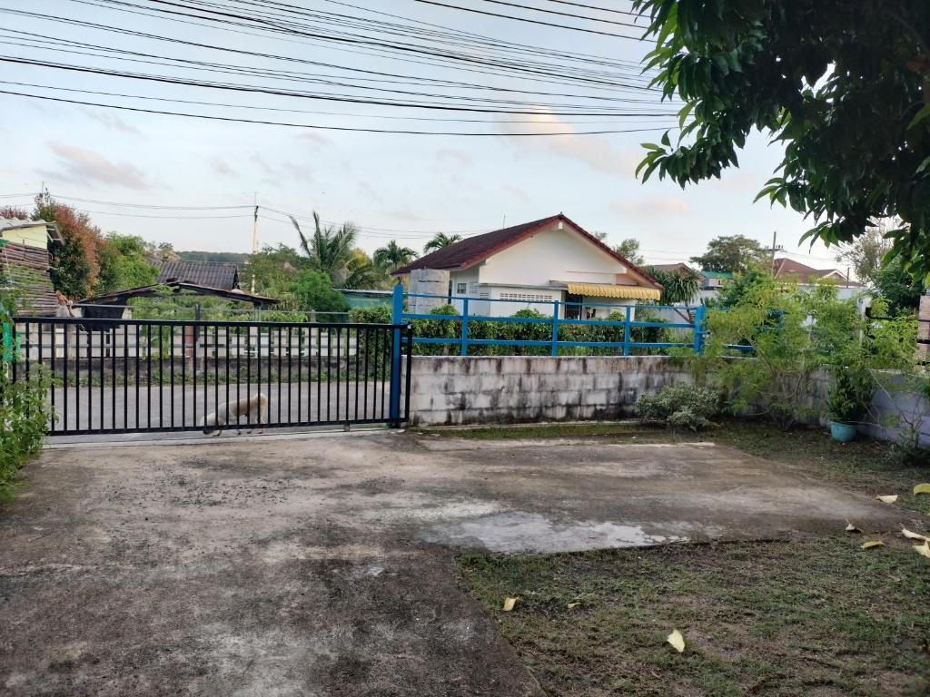 a driveway with a blue gate in front of a house at Soi Saliga in Rawai Beach