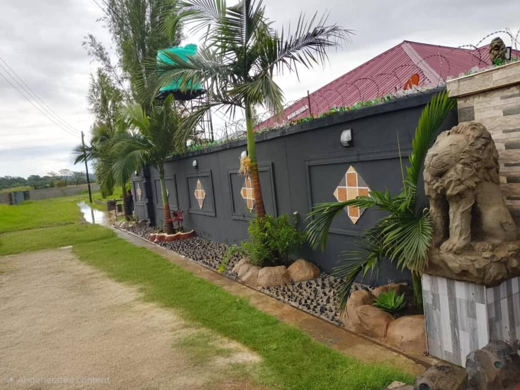 a black building with palm trees in front of it at Seven Palms Executive Lodge in Ndola