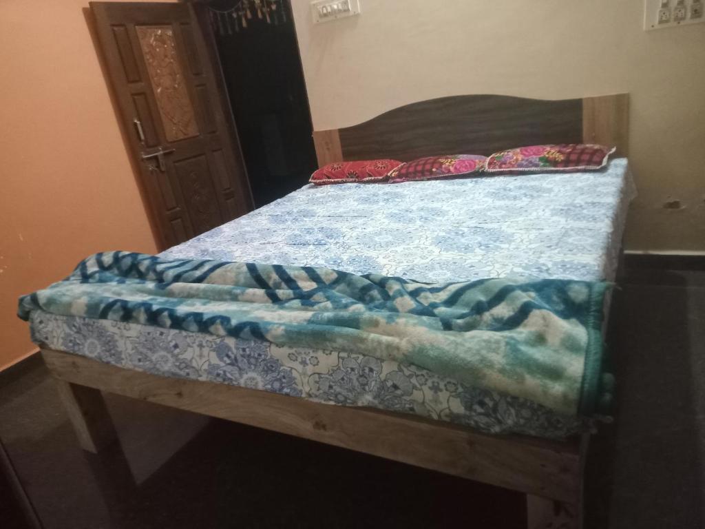 1 cama con manta azul y almohadas en Nagaraj, en Hampi