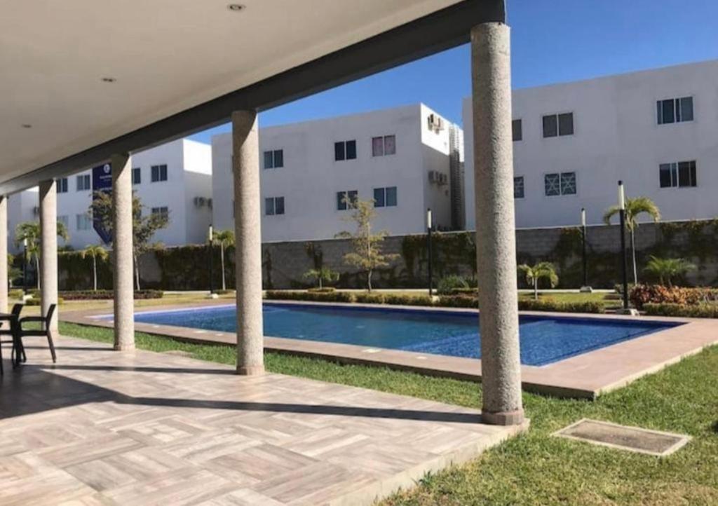 a swimming pool in front of a building at Condominio mzt in Mazatlán
