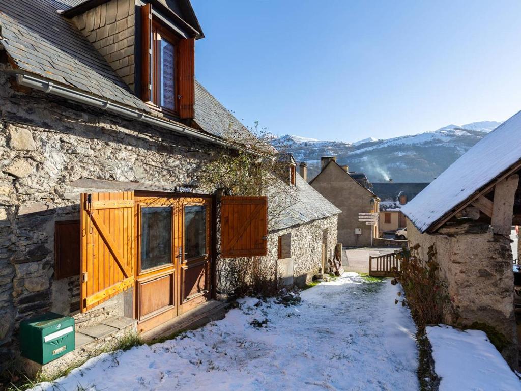 an old house with wooden doors in the snow at Maison pour 5 à Génos proche lac et station avec WiFi - FR-1-695-94 in Génos