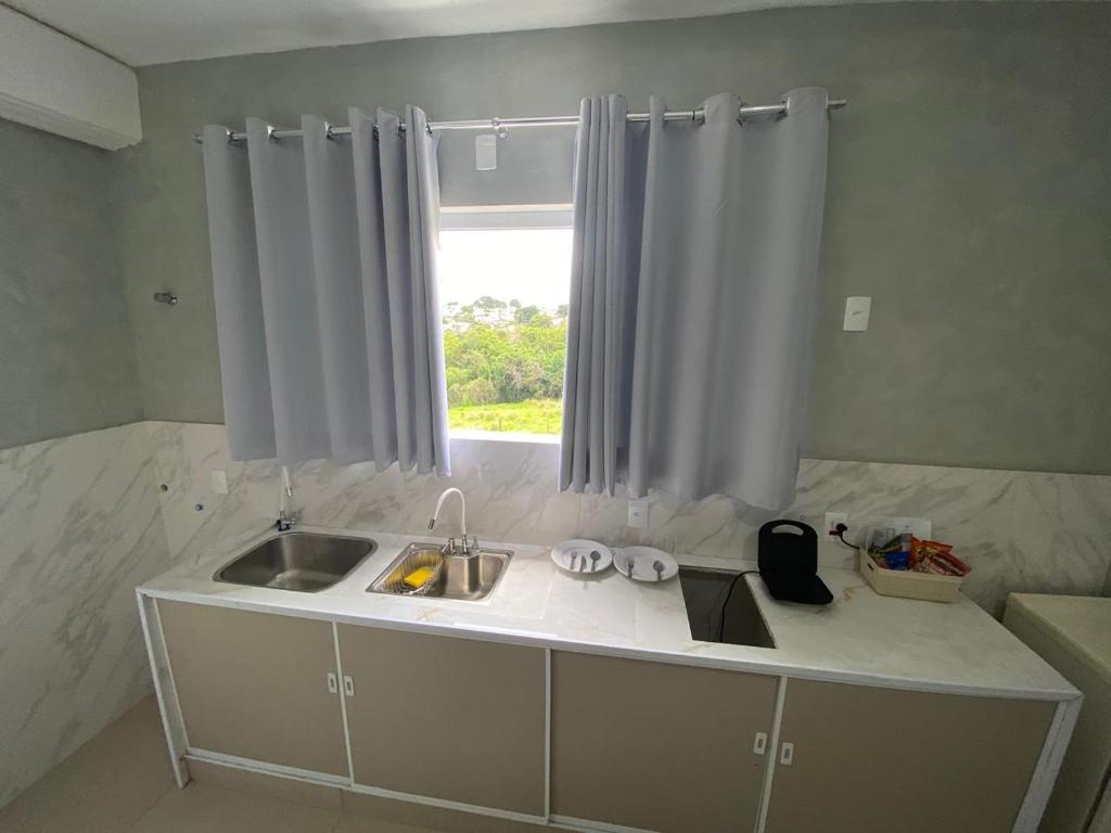 un bancone della cucina con lavandino e finestra di Kitnet Standard Araujo's Suítes 107 a Passos