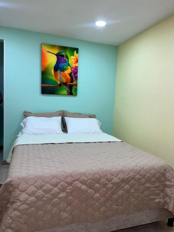 a bedroom with a bed with a painting on the wall at Ebratt Inn in Cartagena de Indias