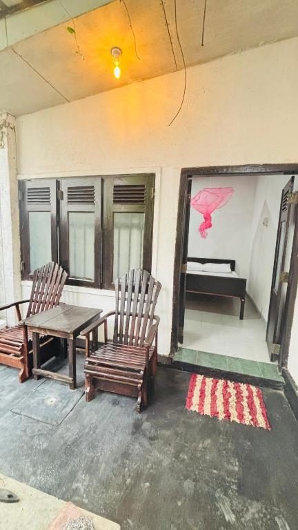 a room with two chairs and a table and a painting at chula,s Home Stay in Matara