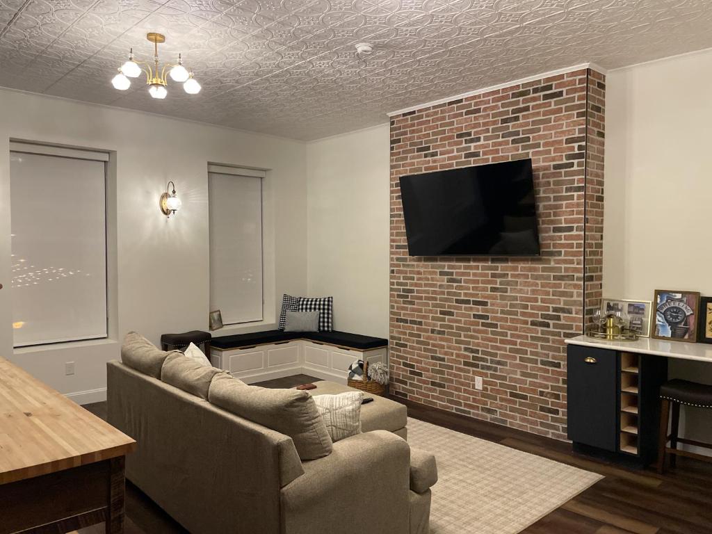 a living room with a couch and a brick fireplace at Historic Market Plaza Overlook in Wheeling