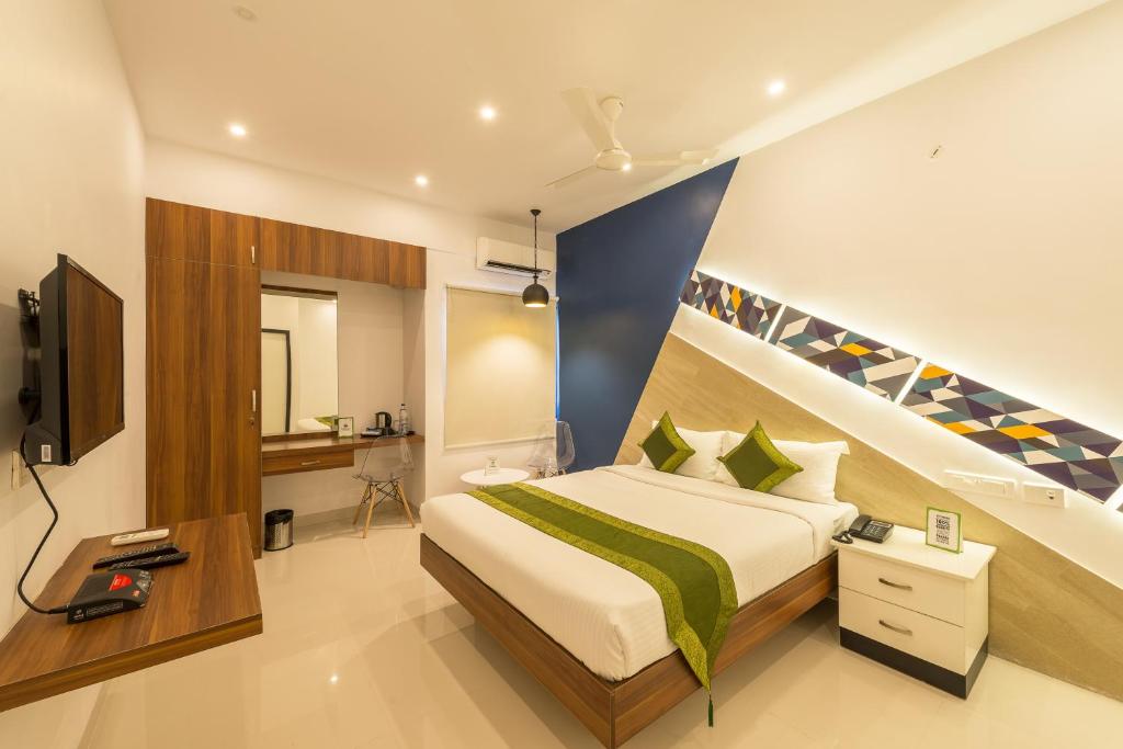 a hotel room with a bed and a television at Itsy By Treebo - Corner stay in Coimbatore