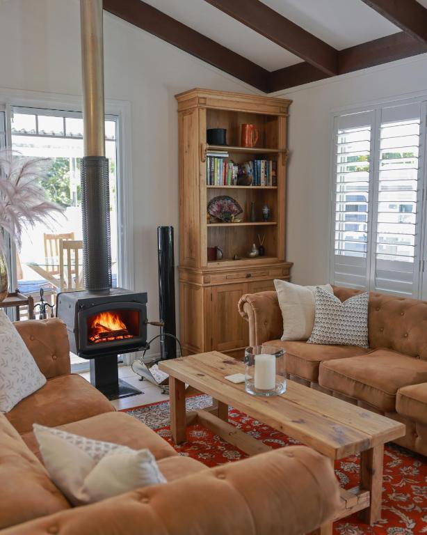 a living room with a couch and a fireplace at Firefly Cottage in Mount Tamborine
