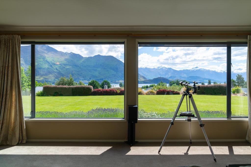 a camera on a tripod next to a window with a view at Beacon Point Lakeview Escape - Spacious - Stylish in Wanaka