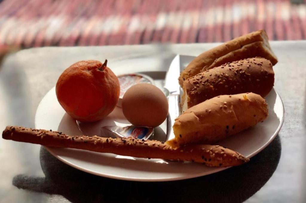 a plate of food with an apple an egg and bread at The Egyptian apartment in Cairo