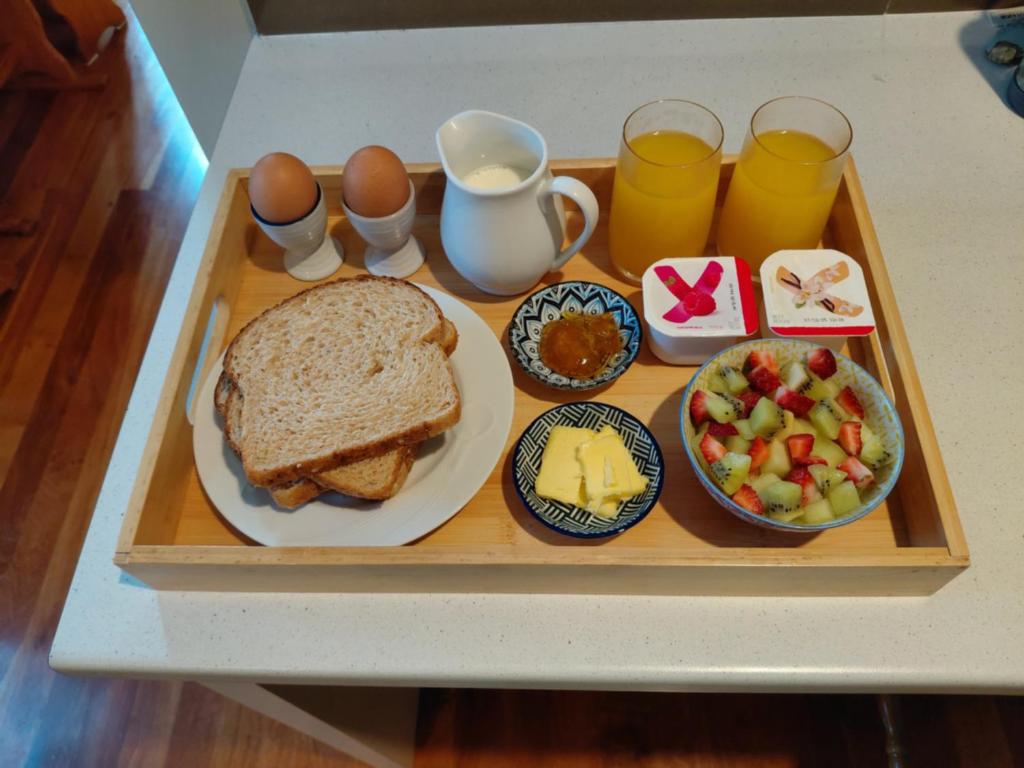 a tray of food with a sandwich and eggs and fruit at Northwood Bed and Breakfast in Perth