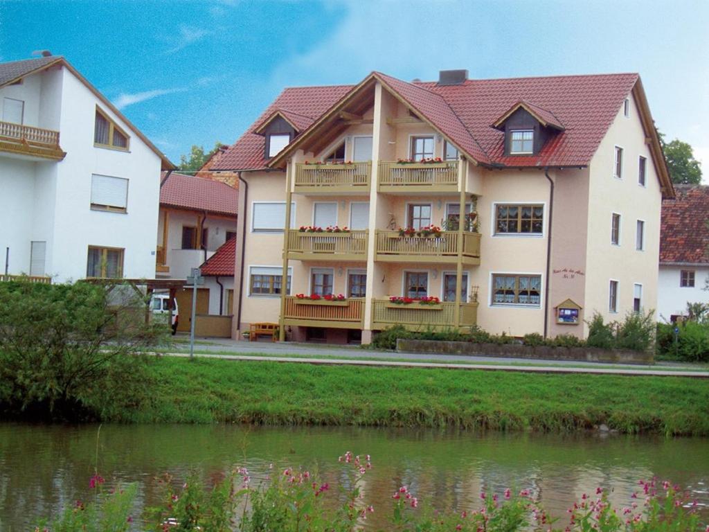 a building with a river in front of it at Haus An der Abens in Bad Gögging