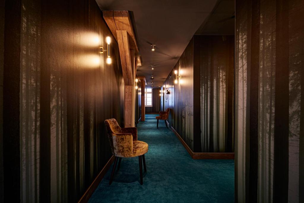 a hallway with a chair in a room with curtains at Boutique Hotel Spedition a member of DESIGN HOTELS in Thun