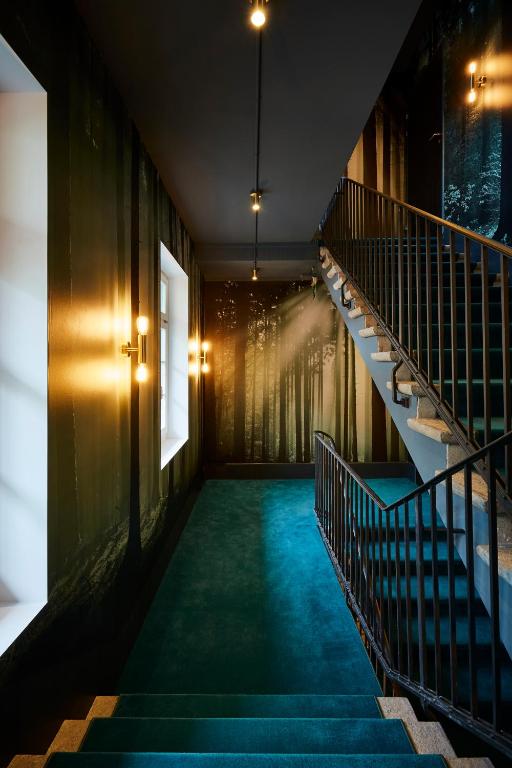 a hallway with stairs in a building with blue carpet at Boutique Hotel Spedition a member of DESIGN HOTELS in Thun