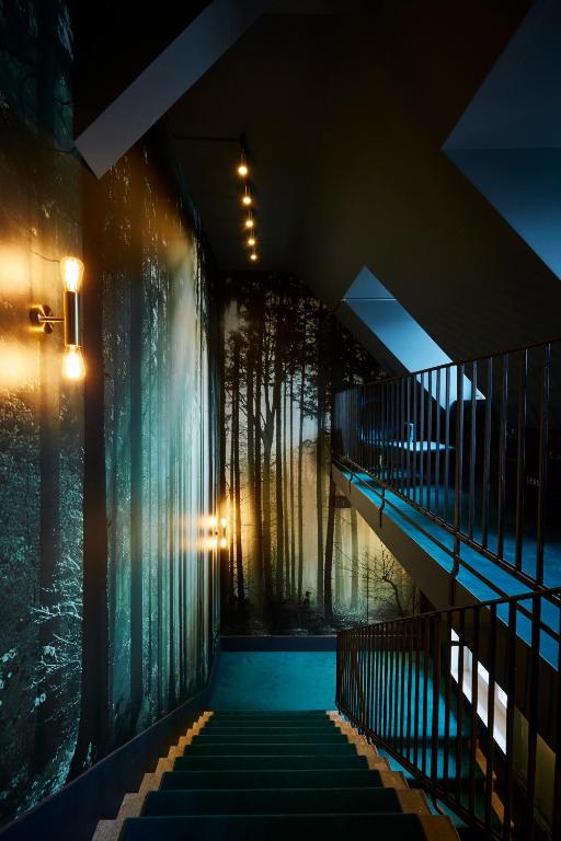 a staircase in a building with a wall of trees at Boutique Hotel Spedition a member of DESIGN HOTELS in Thun