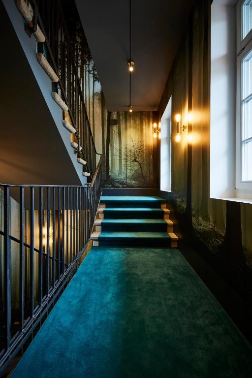 a hallway with stairs and green carpet at Boutique Hotel Spedition a member of DESIGN HOTELS in Thun
