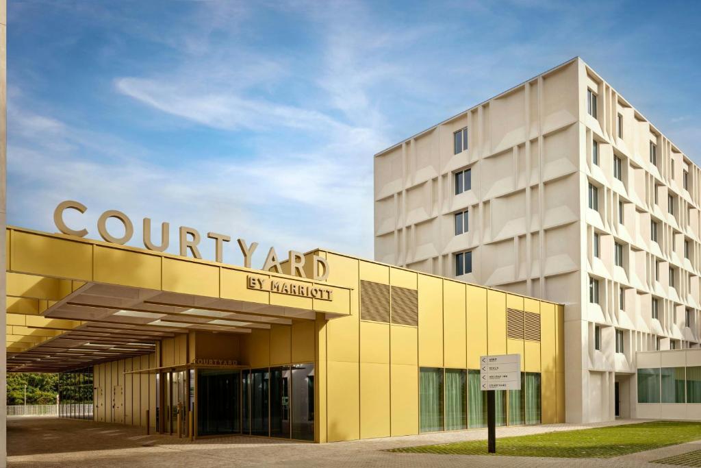 a rendering of a hotel with a yellow building at Courtyard by Marriott Ghent in Ghent