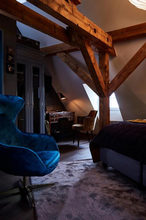a bedroom with a bed and a chair in a room at Boutique Hotel Spedition a member of DESIGN HOTELS in Thun