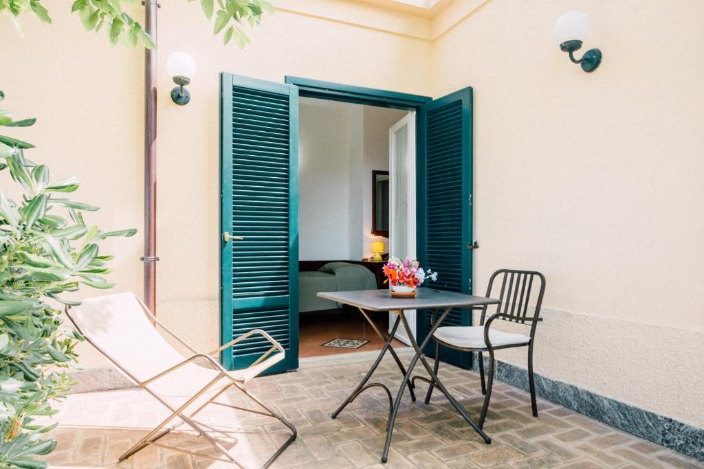 a patio with a table and chairs and a room at Villino Eleonora in Parghelia
