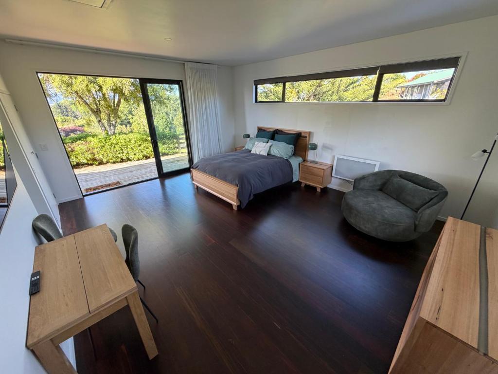 un dormitorio con una cama y una silla en Paradise Found at Studio 65, en Hamurana