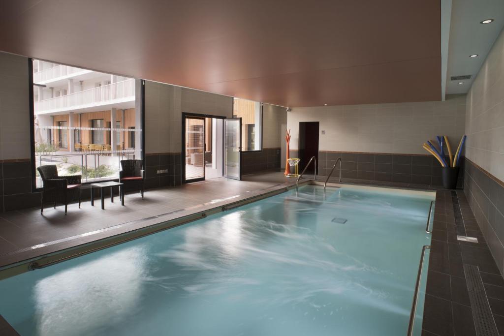 a large swimming pool in the middle of a building at Domitys Le Millésime in Bordeaux