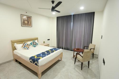a bedroom with a bed and a table and a chair at Samyukta resort in Gogāpur