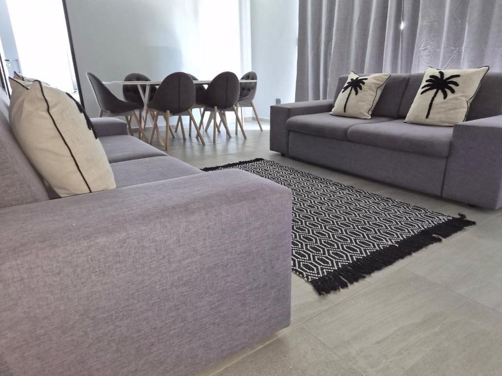 a living room with two couches and a table at Coastal Cove in Cape Town