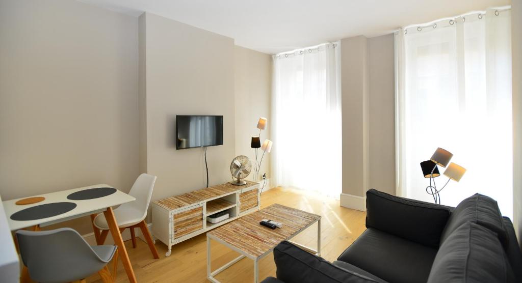 a living room with a couch and a table at Appart' Cuvier in Lyon