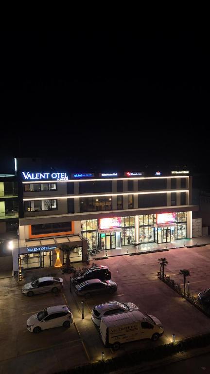 a parking lot with cars parked in front of a building at VALENT OTEL BUSINESS in Mehmetalanı