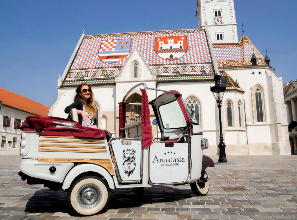 Eine Frau sitzt in einem Wagen vor einem Gebäude. in der Unterkunft Anastasia Suites Zagreb in Zagreb