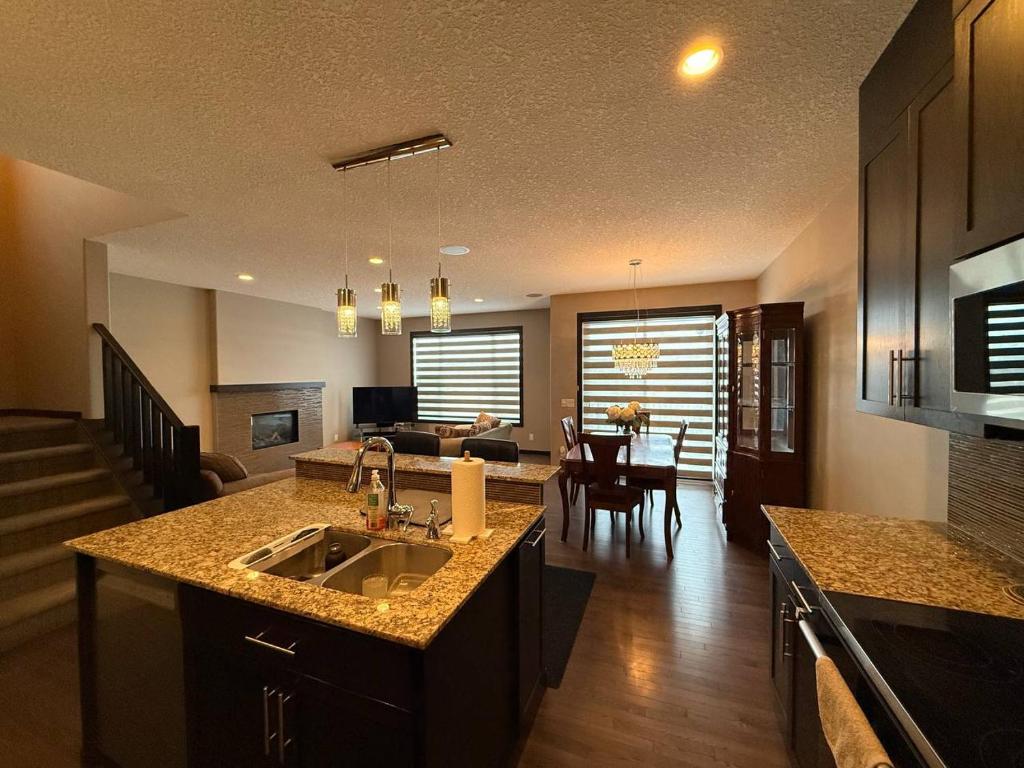 a kitchen and living room with a sink and a counter at Panorama Haven in Calgary