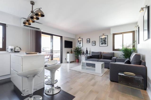 a large living room with a couch and a kitchen at Appartement Residence Athena in Cannes