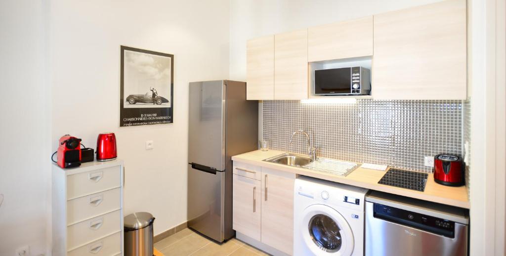 a kitchen with a refrigerator and a washing machine at Appart&#39; Lyonnais in Lyon