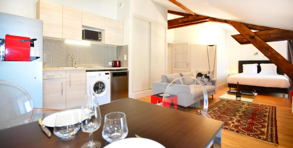 a kitchen and living room with a table and wine glasses at Appart&#39; Lyonnais in Lyon