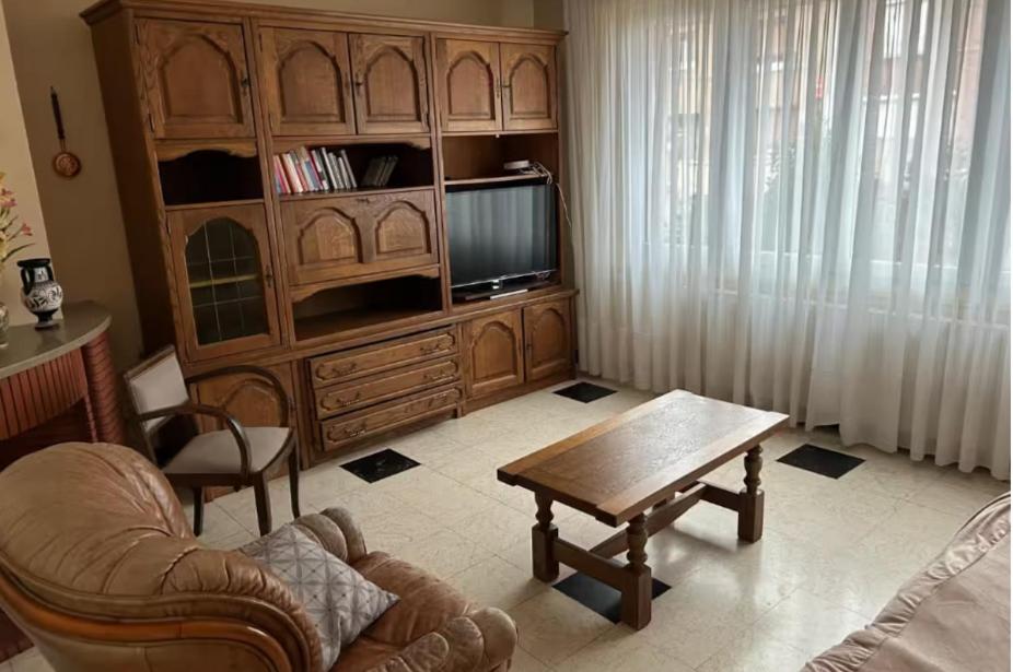 een woonkamer met een houten entertainmentcentrum en een salontafel bij La maison du coeur in Coudekerque-Branche