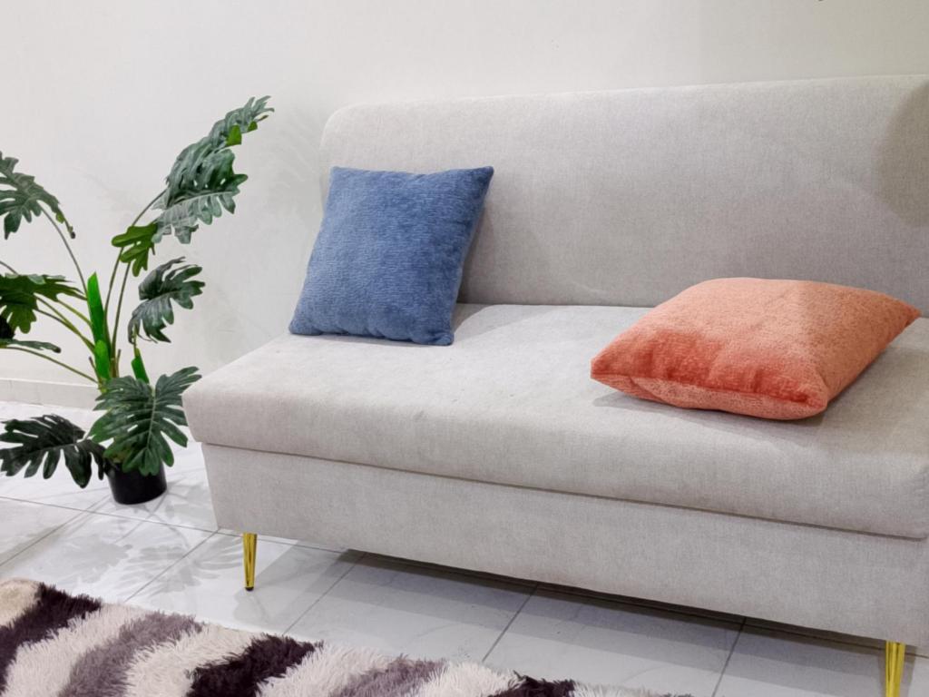 a couch with two pillows on it in a living room at وادي جليل in As Sifyānī