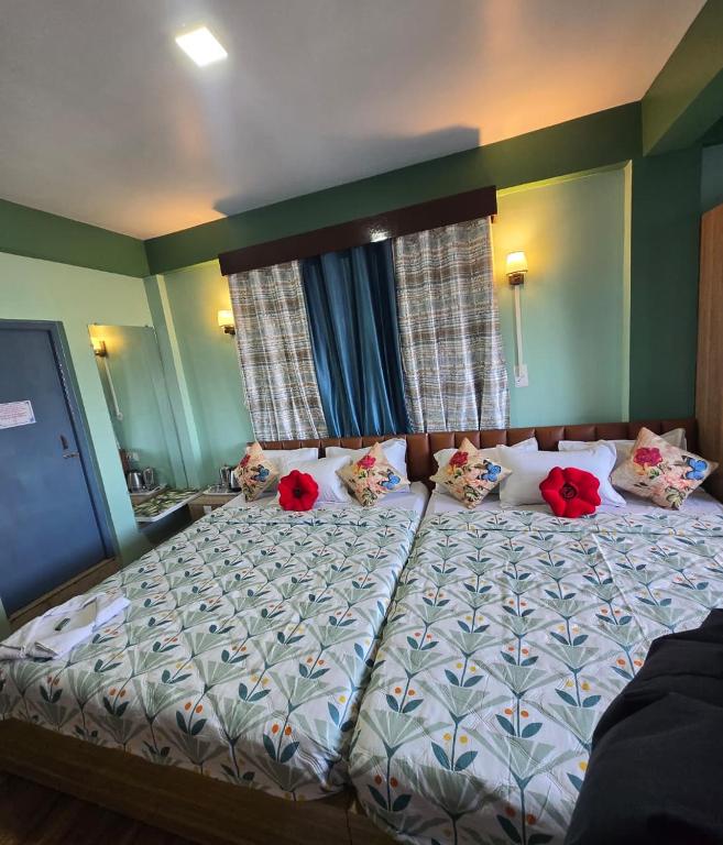 a bedroom with a bed with red flowers on it at Sonali Megh in Darjeeling