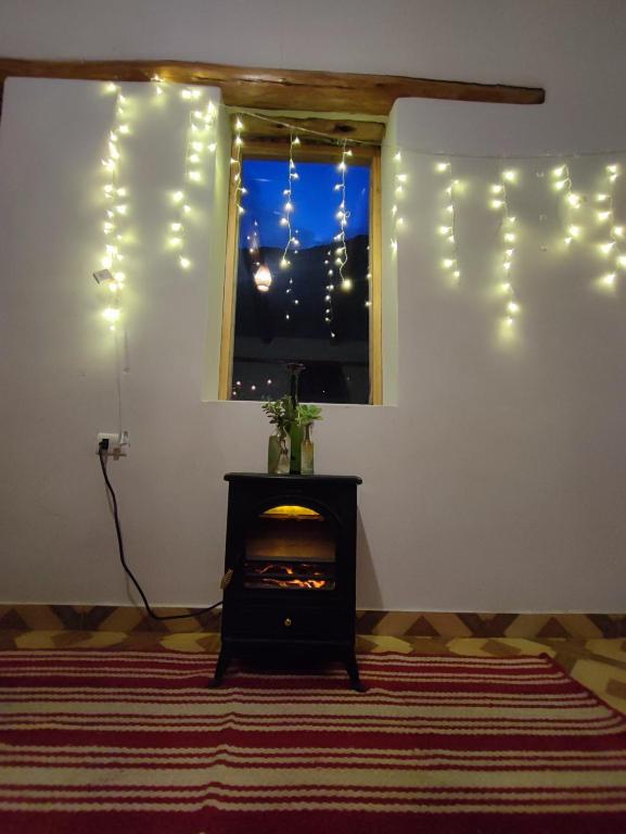 ein Wohnzimmer mit einem Fenster mit Weihnachtsbeleuchtung in der Unterkunft Loft acogedor in Ollantaytambo